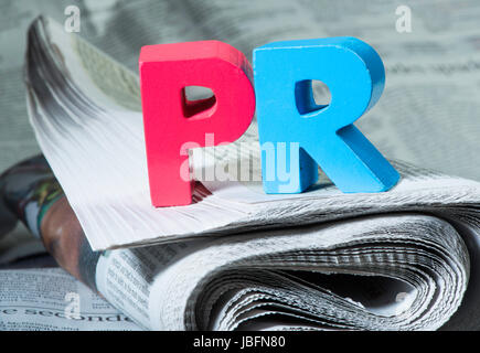 Word PR on newspaper. Wooden letters Stock Photo