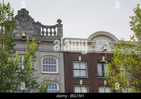 AMSTERDAM, NETHERLANDS - 6 SEPT. 2013: Adjoint canal houses with typical cornices in Amsterdam, one with open balustrade. Many of the canal houses were built for the aristocracy more than 400 years ago and are now in use as houses, offices and shops. The canal district is a Unesco World Heritage site Stock Photo