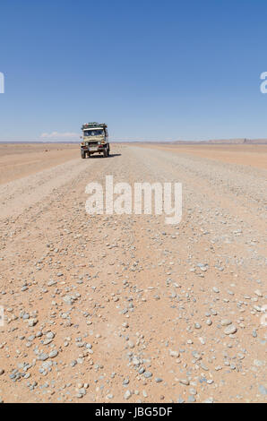 Land Cruiser 4x4 on empty rocky desert road to Erg Chebbi in the Moroccan Sahara, Africa. Stock Photo