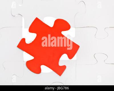 red puzzle piece on free space in layer assembled puzzles Stock Photo