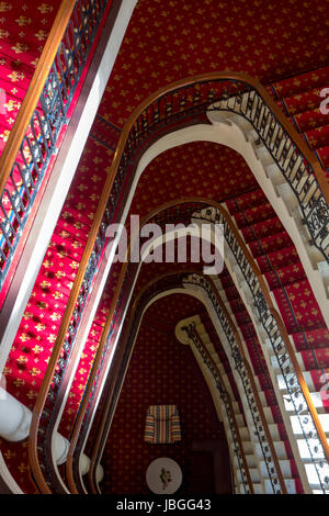 Massive red old classic staircase see from above in Bilbao hotel with view on comfortable lobby, Spain. Stock Photo