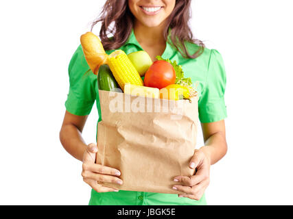 Image of paper packet full of different fruits and vegetables held by smiling female Stock Photo