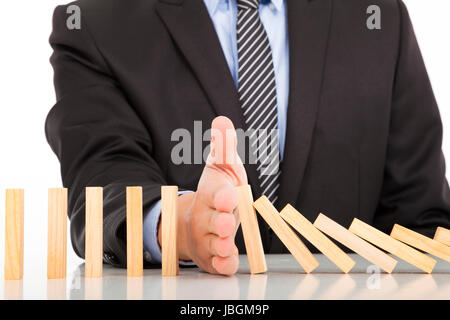 businessman hand stop dominoes continuous toppled Stock Photo