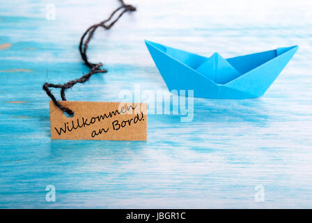 Tag with the german words Willkommen an Board which means Welcome on Board, blue Background Stock Photo