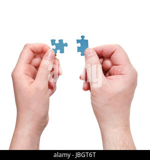 male and female hands connecting little puzzle pieces isolated on white background Stock Photo
