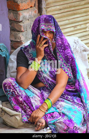 Local woman sitting at the street market in Fatehpur Sikri, Uttar Pradesh, India. The city was founded in 1569 by the Mughal Emperor Akbar, and served Stock Photo