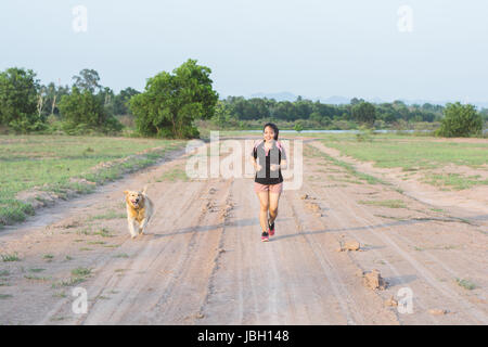 Happy young woman jogging with her beagle dog Stock Photo