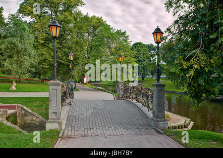 Small bridge with lampposts across canal in city park of Riga, Latvia. Stock Photo