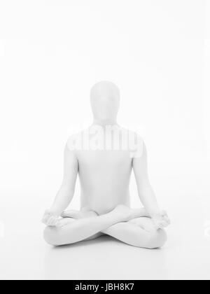 faceless man dressed in white sitting in yoga lotus position, front view Stock Photo