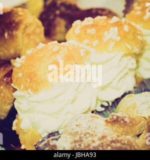 Vintage retro looking Mixed pastries with chocolate, cream, fruit useful as background Stock Photo