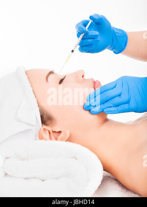 Beautiful woman gets injection in her face Stock Photo