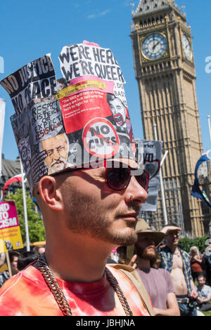 June 10, 2017 - London, UK - London, UK. 10th June 2017. A man wears a hat with messages against the cuts at the rally in Parliament Square celebrating the remarkable performance against all the odds made by Labour led by Jeremy Corbyn in the General Election. They call for support for him inside and outside the Labour Party and for the fight for Labour values to continue and for all Labour MPs to get behind a leader who has shown he can grow the Labour vote. Speakers called for Theresa May to go, and expressed disgust at her making a pact with the far right DUP with its bigotry and close conn Stock Photo