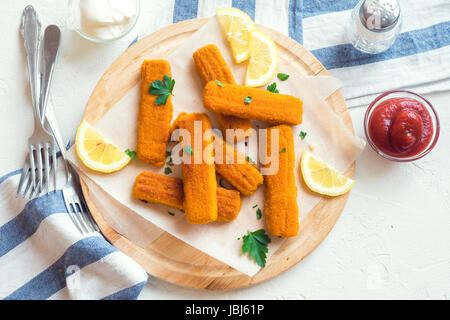 Fried Fish Sticks. Fish Fingers. Fish Sticks with lemon and sauces ready to eat. Stock Photo