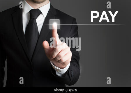 man in black suite pressing virutal button pay Stock Photo
