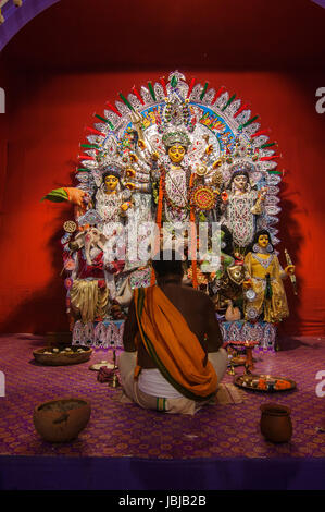 KOLKATA , INDIA - OCTOBER 11, 2013 : Priest praying to Goddesss Durga, Durga Puja festival celebration. It is the biggest religious festival of Hinduism and local Bengali community Stock Photo