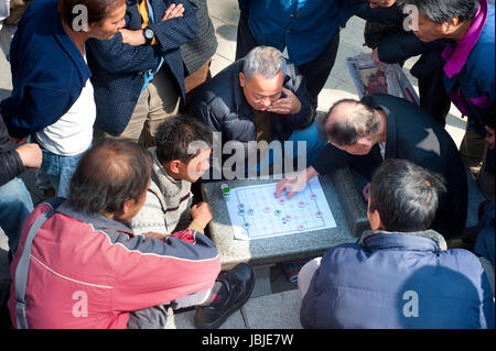 HONG KONG - JANUARY 19, 2013: Group of people plaing xiangqi. Xiangqi, also called Chinese chess, is one of the most popular board games in China Stock Photo