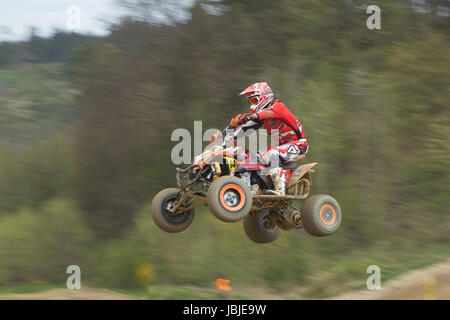 MOHELNICE,  CZECH REPUBLIC - APRIL 19: Racer in red is jumping a quad motorbike in the 'International Championship of the Czech Republic 2014' on April 19, 2014  in MOHELNICE, Czech Republic. Stock Photo