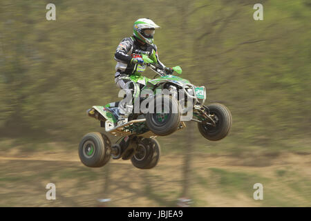 MOHELNICE,  CZECH REPUBLIC - APRIL 19: Racer in green is jumping a quad motorbike in the 'International Championship of the Czech Republic 2014' on April 19, 2014  in MOHELNICE, Czech Republic. Stock Photo