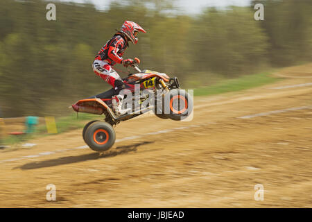 MOHELNICE,  CZECH REPUBLIC - APRIL 19: Racer in red is riding a quad motorbike in the 'International Championship of the Czech Republic 2014' on April 19, 2014  in MOHELNICE, Czech Republic. Stock Photo