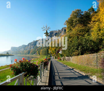 Promenade in der Sächsischen Schweiz entlang der Elbe in Deutschland; bunte Blumenkästen, Herbstwälder und die schroffen Felsen der Bastei Promenade in Saxon Switzerland along the Elbe in Germany; colorful flower boxes, autumn forests and the craggy rocks of the Bastei Stock Photo