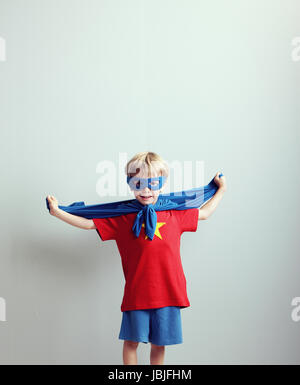 A young boy dreams of becoming a superhero. Stock Photo