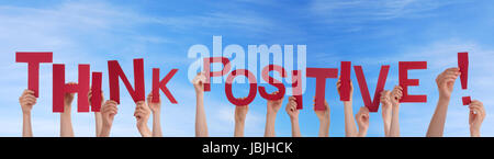 Many Hands Holding the Words Think Positive in the Sky Stock Photo