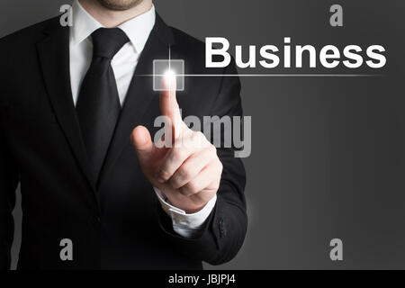 man in black suite pressing virutal button business Stock Photo