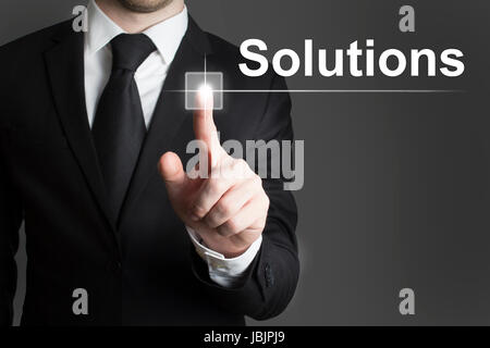 man in black suite pressing virutal button solutions Stock Photo