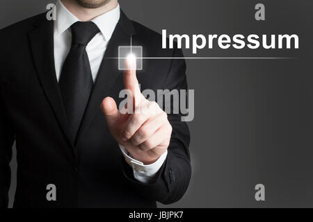man in black suite pressing virutal button impressum Stock Photo