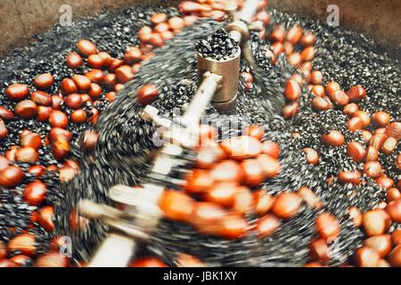 Preparation of the roasted chestnuts on the street market in Kuala Lumpur - blurred motion Stock Photo