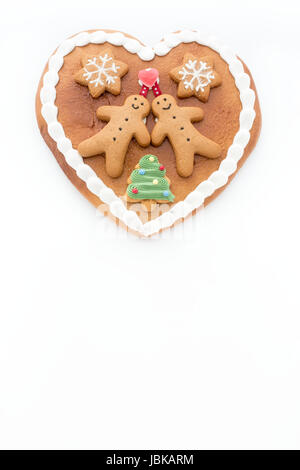 Gingerbread heart decorated with Gingerbread Men, Gingerbread Stars and a Christmas Tree Cookie on white background with lots of copy space. Stock Photo