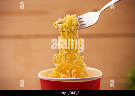 Eating Instant noodles in cup with a fork Stock Photo