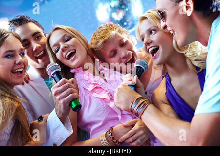 Portrait of joyous friends singing at party together Stock Photo