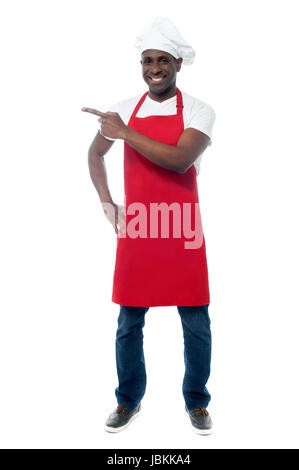 Full length portrait of chef in uniform pointing away Stock Photo