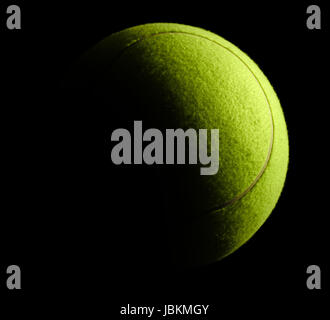 a yellow tennis ball in black back Stock Photo