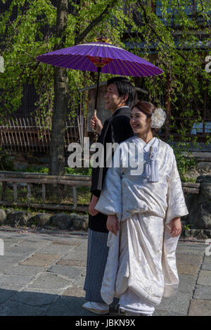 Japanese couple dressed in traditional costume, having their photographs taken a few days before the actual wedding. Stock Photo