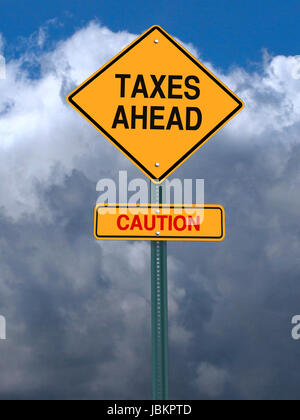 conceptual post sign caution taxes ahead sign over dramatic sky Stock Photo