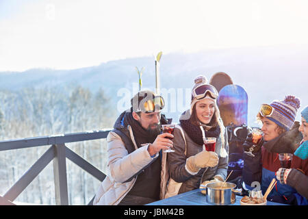 Snowboarder and skier friends drinking cocktails on balcony apres-ski Stock Photo