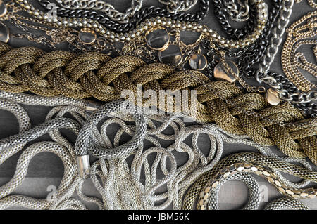 Mix of different size, color and texture chains on wooden background Stock Photo