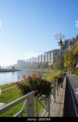 Promenade in der Sächsischen Schweiz entlang der Elbe in Deutschland; bunte Blumenkästen, Herbstwälder und die schroffen Felsen der Bastei Promenade in Saxon Switzerland along the Elbe in Germany; colorful flower boxes, autumn forests and the craggy rocks of the Bastei Stock Photo