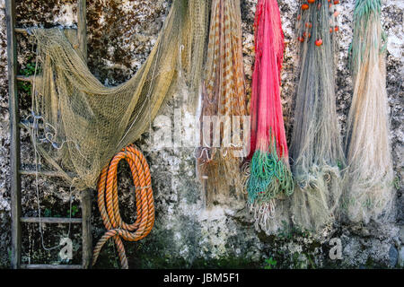An old fishing net hanging on rustic wooden wall Stock Photo - Alamy