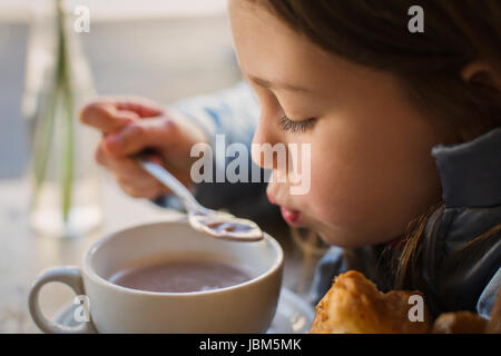Close up girl blowing on hot soup Stock Photo