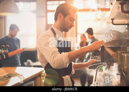 Male barista using espresso machine in cafe Stock Photo