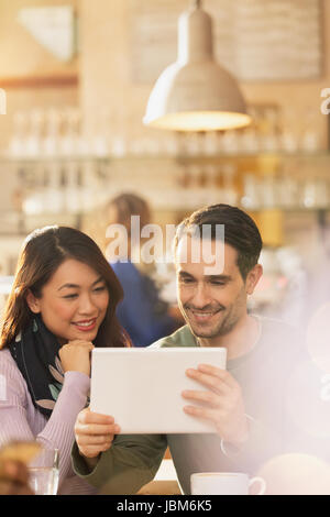Couple using digital tablet in cafe Stock Photo