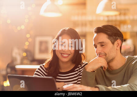 Smiling couple video chatting at laptop in cafe Stock Photo