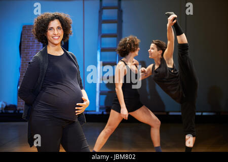Portrait of pregnant woman teaching dance in theater and looking at camera, smiling in backstage Stock Photo