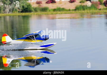 A floating Radio controlled model seaplane speeds up to take off on Guadiana river, Badajoz Stock Photo