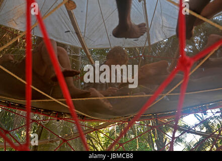 Festival-goers chill out on a suspended trampoline in the Envision village at the 2015 Envision Festival, a transformational festival on Costa Rica's  Stock Photo