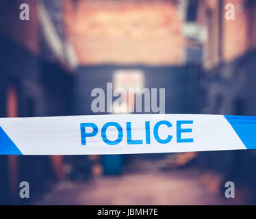 British Police Tape Around A Crime Scene In A Grungy Urban Alley Stock Photo