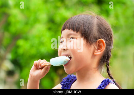 happy little girl eating popsicle at summertime Stock Photo